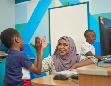 Explore learning tutor high fiving a child in a centre