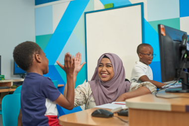 Explore learning tutor high fiving a child in a centre