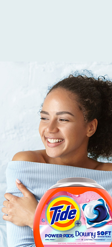 A young woman enjoying the softness of her sweater washed with Tide Plus Downy for sensitive skin.