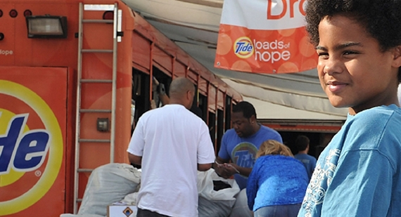 A child getting his clothes cleaned at a Tide Loads of Hope truck