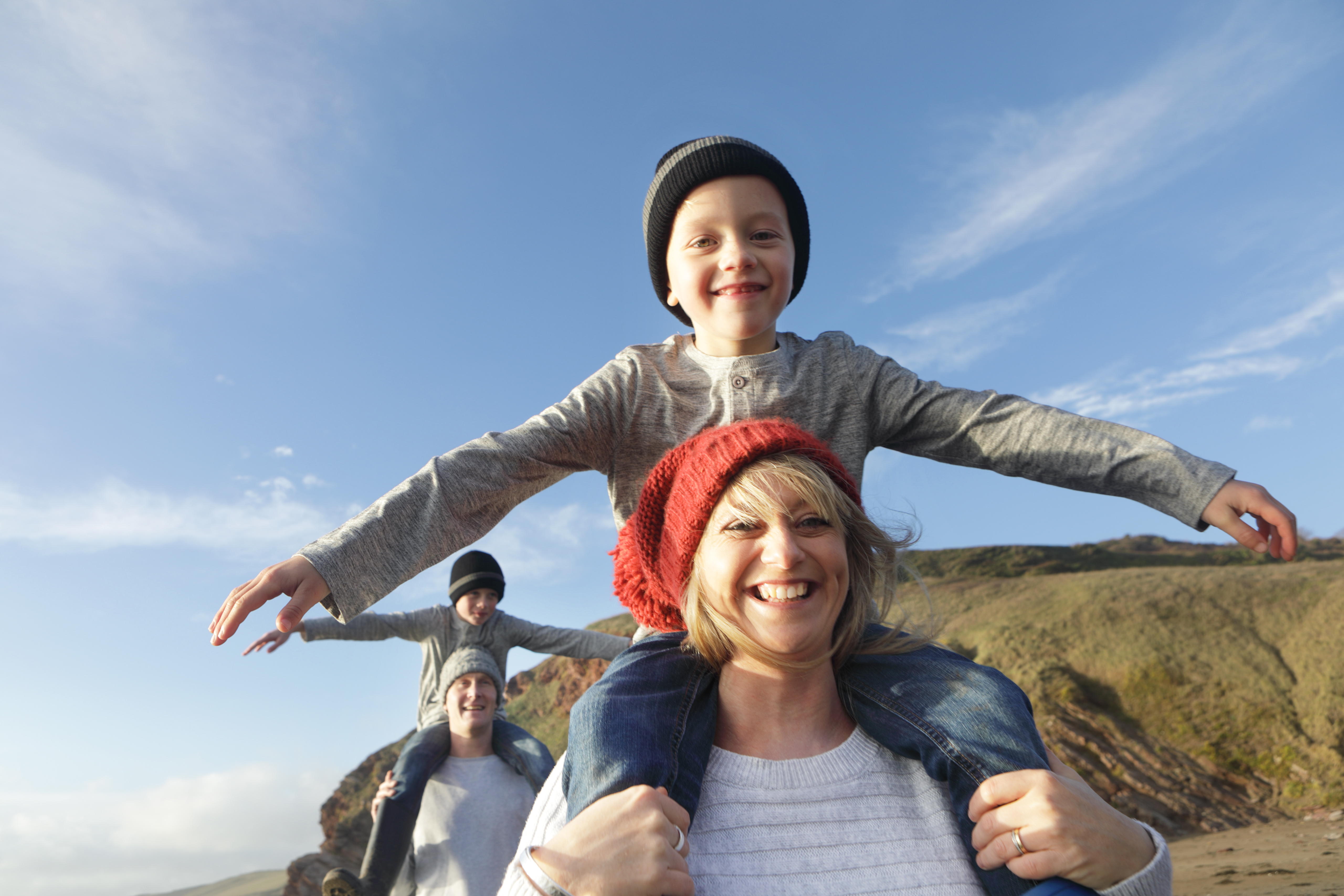 Parents carrying children on their shoulders