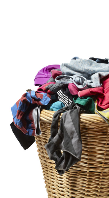 A basket full of dirty clothes waiting to be washed with Tide Plus Febreze Laundry Detergent