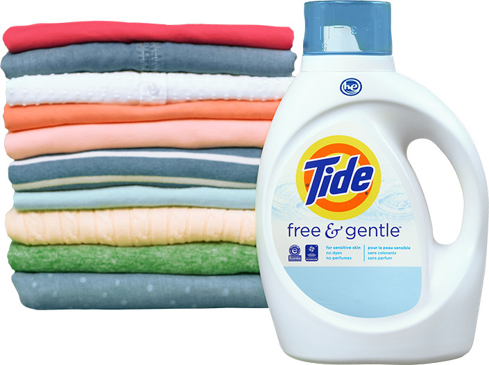 A white bottle of Tide Free and Gentle liquid laundry detergent next to colorful folded clothes