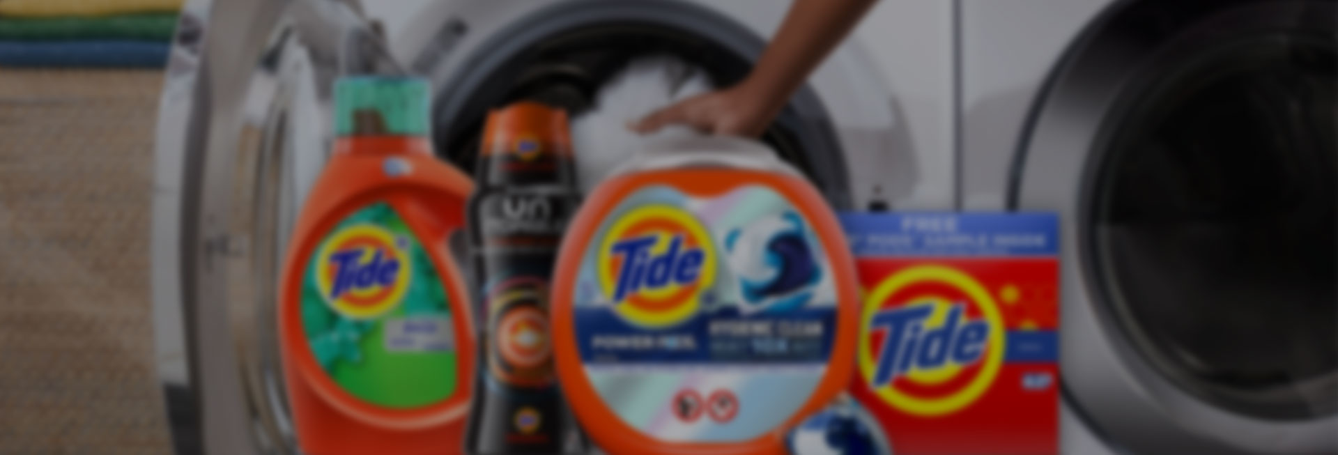 Various Tide products in front of a washer
