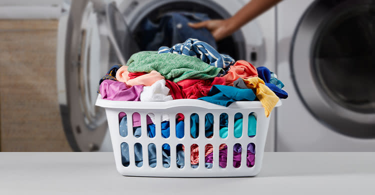 A pile of colored clothes in a laundry basket
