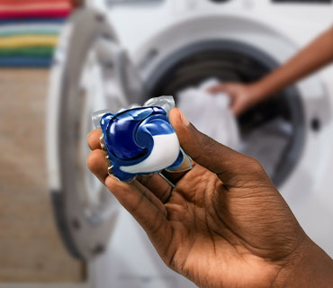 A person holding a Tide PODS washing capsule