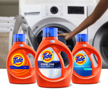 A range of Tide liquid laundry detergent products in front of a white washing machine