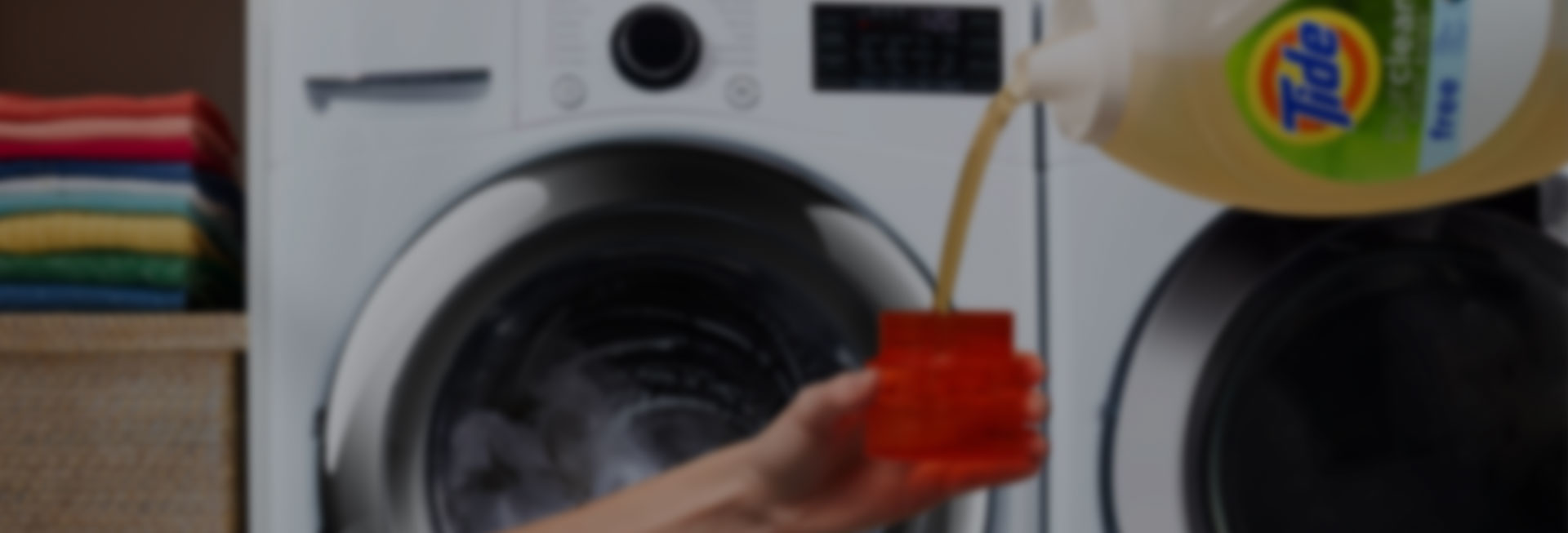 A person pouring Tide liquid laundry detergent into a measurement cup