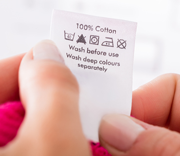 A person holding a garment's fabric care label