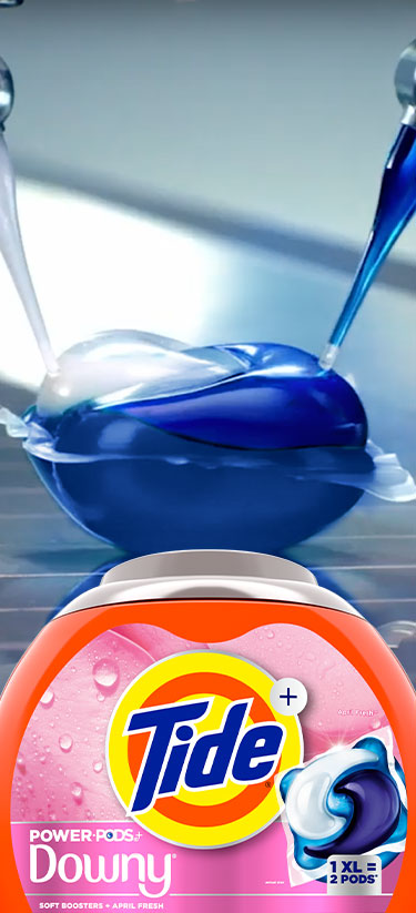Tide PODS on an assembly line with a packshot of a Tide Plus Downy PODS box in the foreground.
