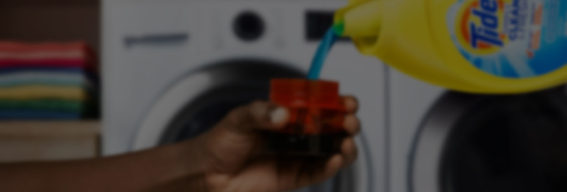 A person pouring Tide liquid laundry detergent into a measurement cup
