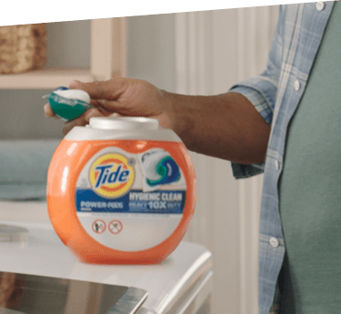 A box of Tide Hygienic Clean PODS on top of a white washing machine in use