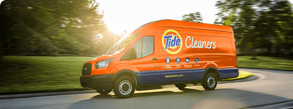 An orange Tide Cleaners van with the logo on its side