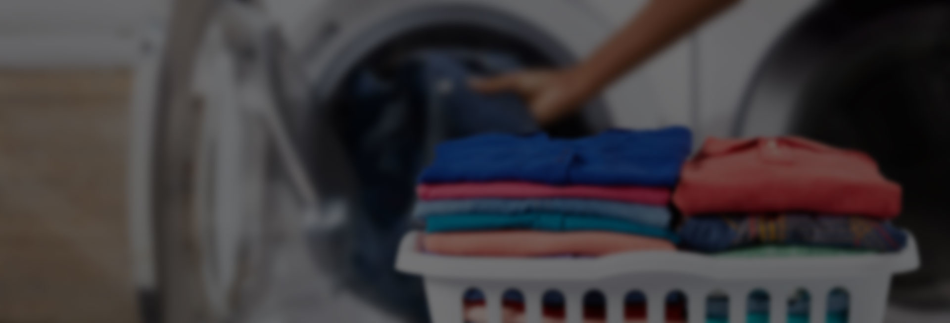 A person loading clothes into a washing machine