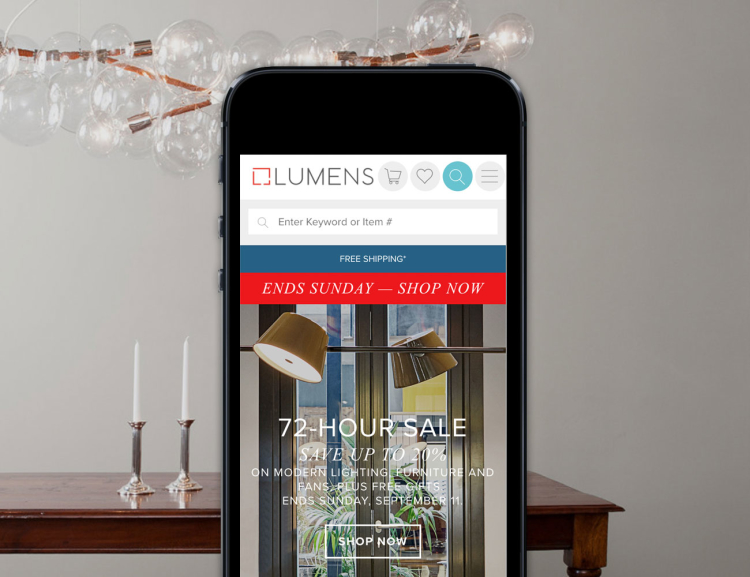 Lumens website shown on mobile device with a ceiling light in the background