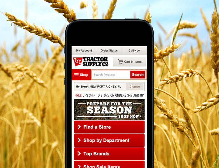 Tractor Supply website shown on mobile device with a wheat field in the background