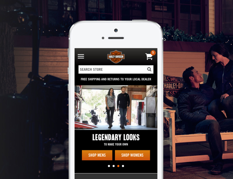 Harley Davidson website shown on mobile device with motorcycles in the background