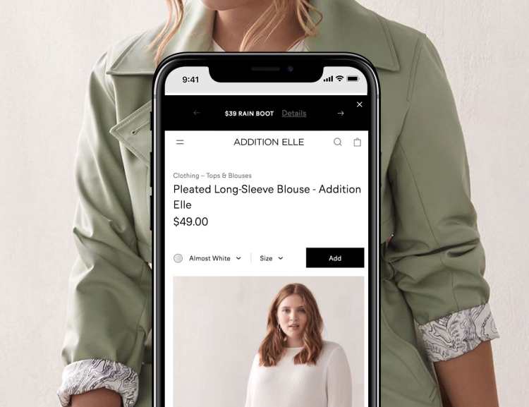 Addition Elle website shown on mobile device with model in the background