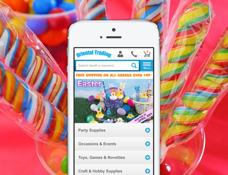Oriental Trading website shown on mobile device with candy in the background