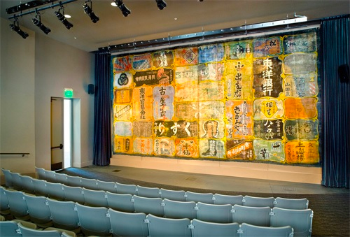 The advertising curtain from the historic Nippon Kan in Seattle’s Japantown is now displayed in The Wing’s Tateuchi Story Theatre.