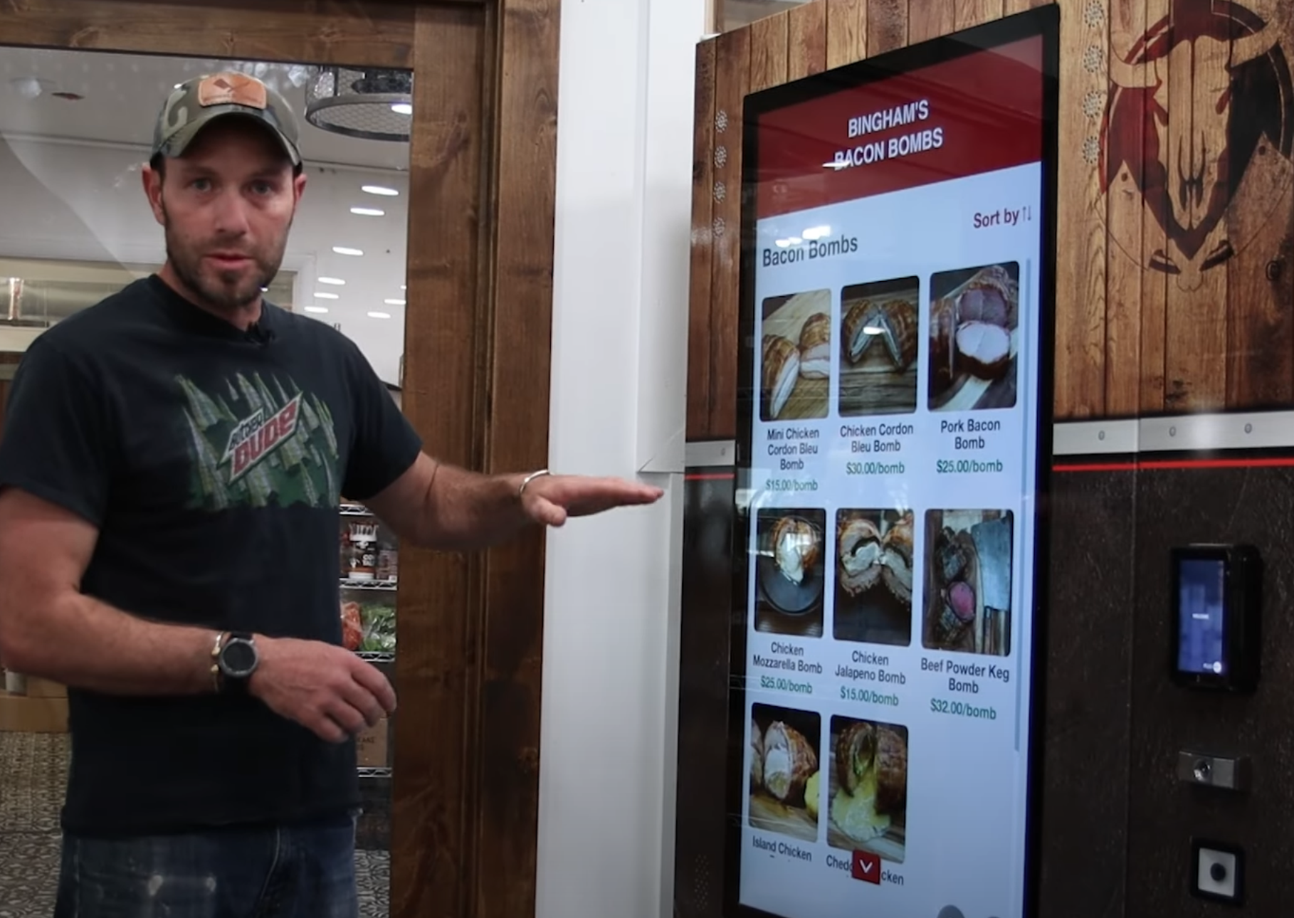 Picture of a man in a baseball hat pointing at a vending machine that sells meat.