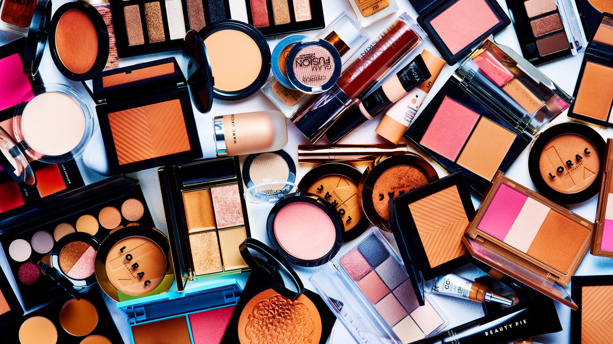 An image of lots os different makeup products on a white table. 