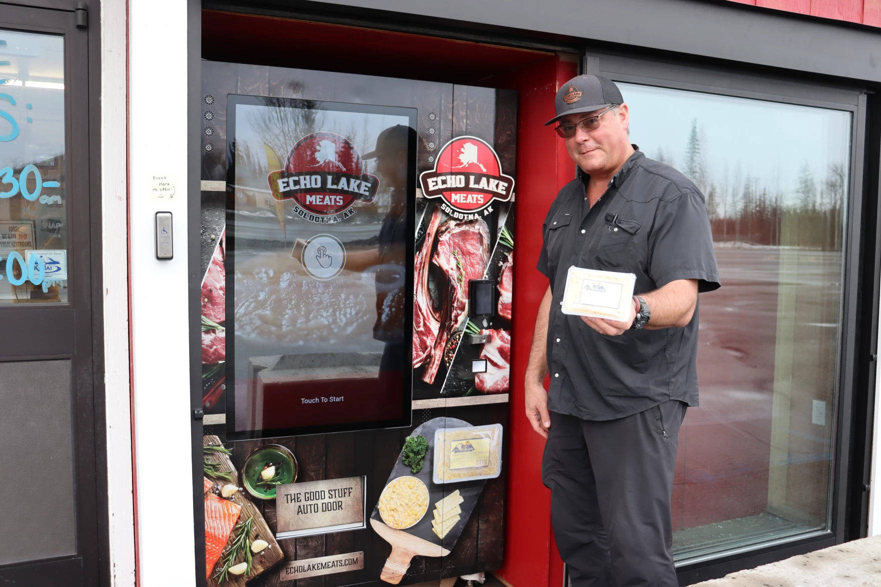 An image of the owner of Echo Lake Meats posing in front of his vending machine.