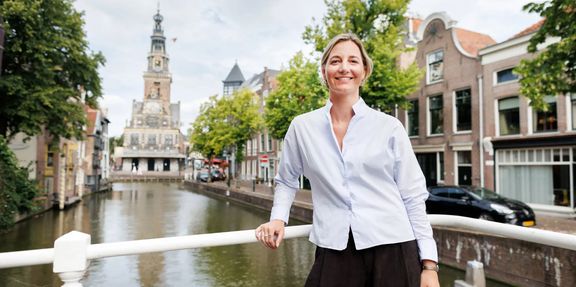 Makelaar Romy van de Leygraaf op een brug in de binnenstad van Alkmaar. 