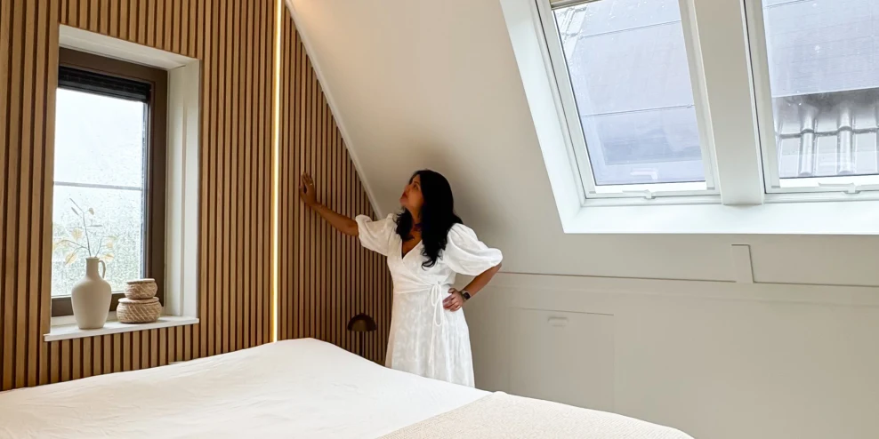 Influencer Amanda van Dijke in haar slaapkamer, kijken naar een wand met houten lambrisering.
