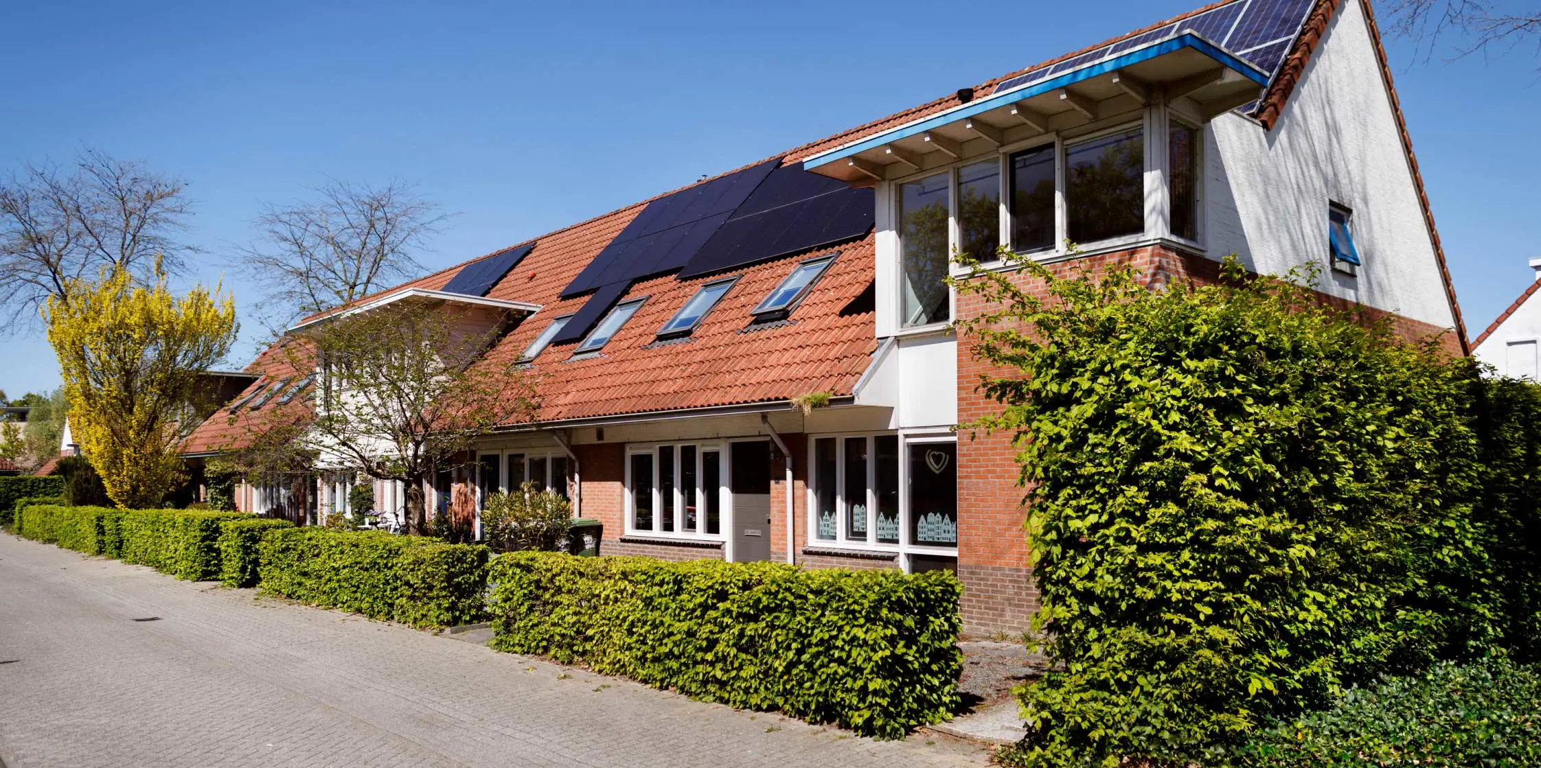 Een aantal rijtjeswoningen met zonnepanelen. 