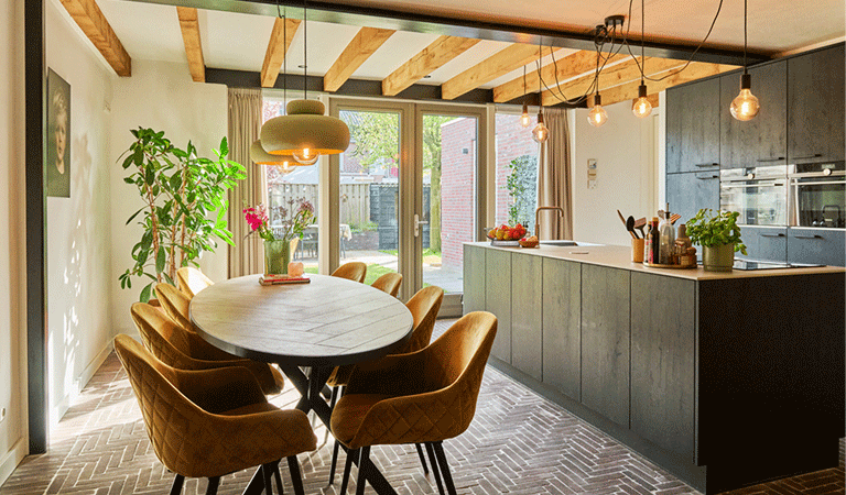 Doorkijkje van de verbouwde keuken met aanbouw naar de achtertuin van de twee-onder-een-kapwoning van Maarten en Femke.