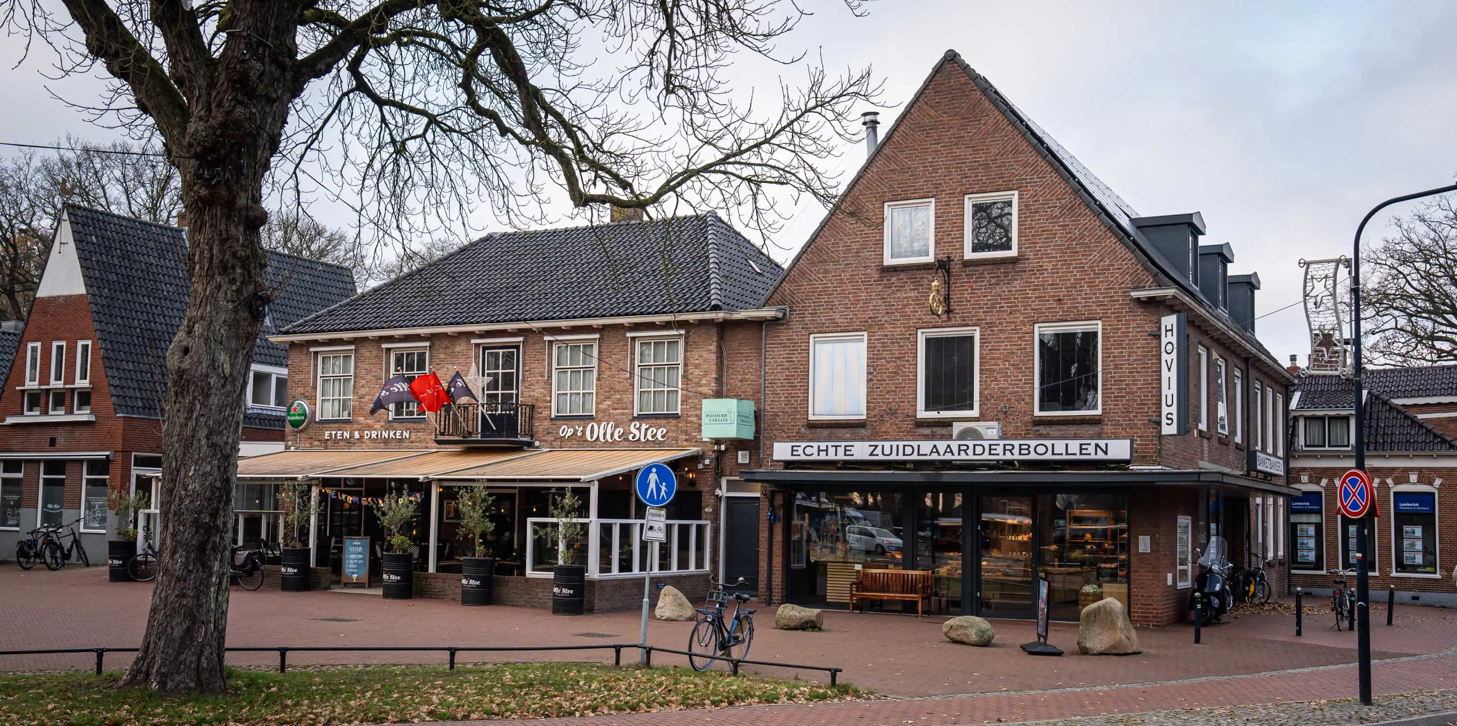 Straatbeeld van Zuidlaren, met de bakker die echte Zuidlaarderbollen verkoopt en links een restaurant. 