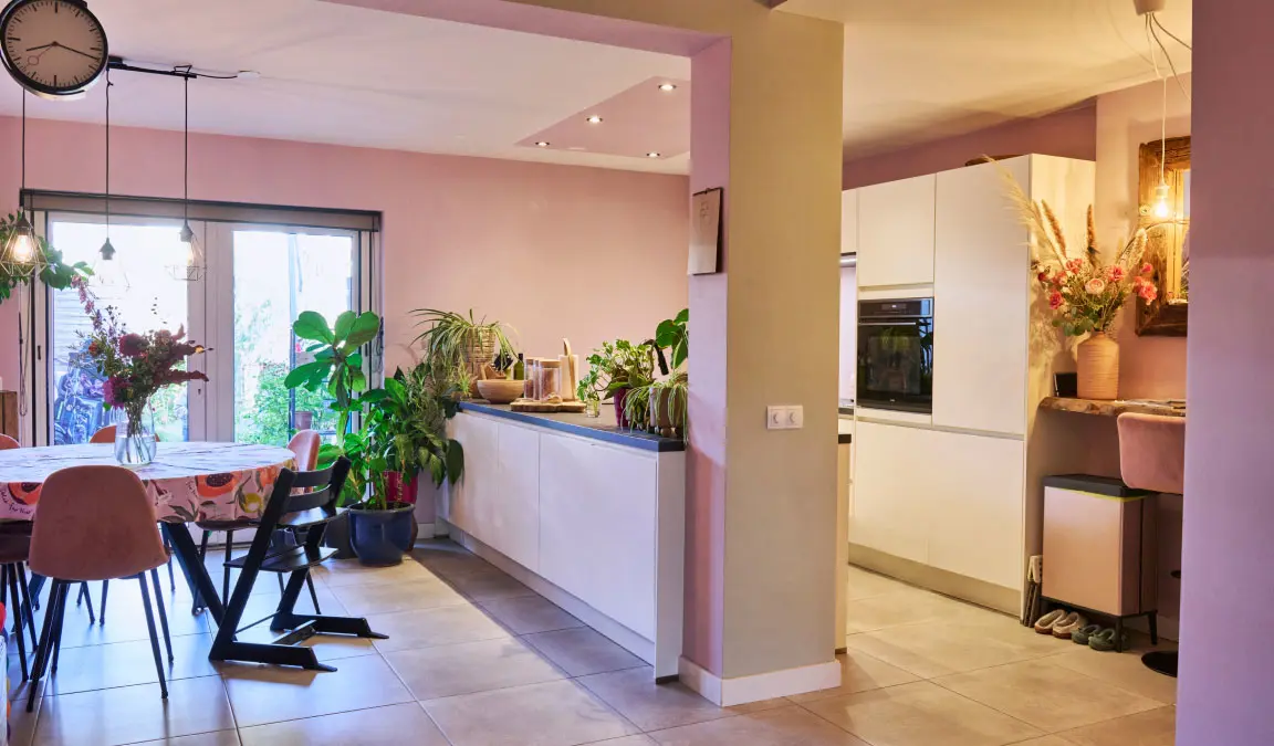 De vernieuwde keuken van de tussenwoning van Lieke in Helmond, met een ronde eettafel en doorkijkje naar de uitbouw en achtertuin.