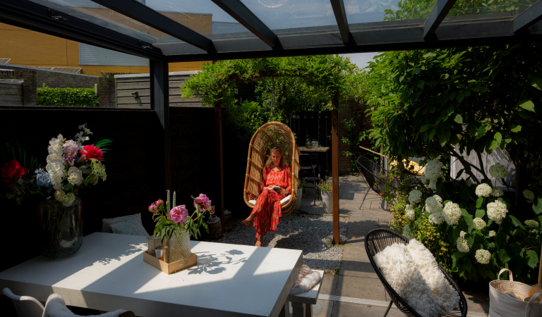 Wendel in een hangstoel in de aangebouwde veranda in Alphen aan den Rijn.