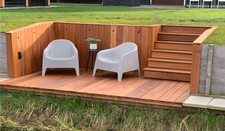 Verlaagd vlonderterras aan het water met daarop twee stoelen.