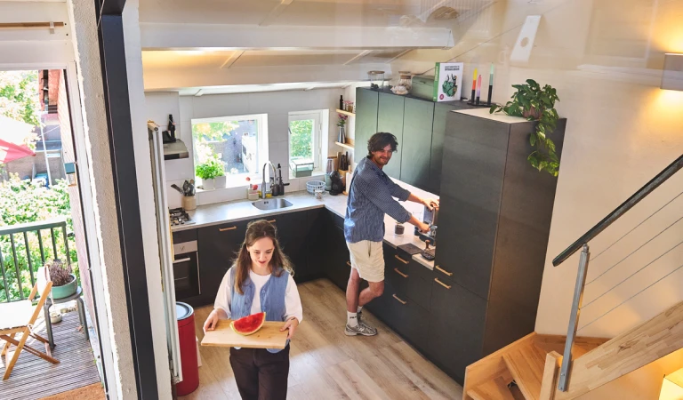 Starters Joost en Myrhte zijn bezig in hun donkergroene, halfopen hoekkeuken.