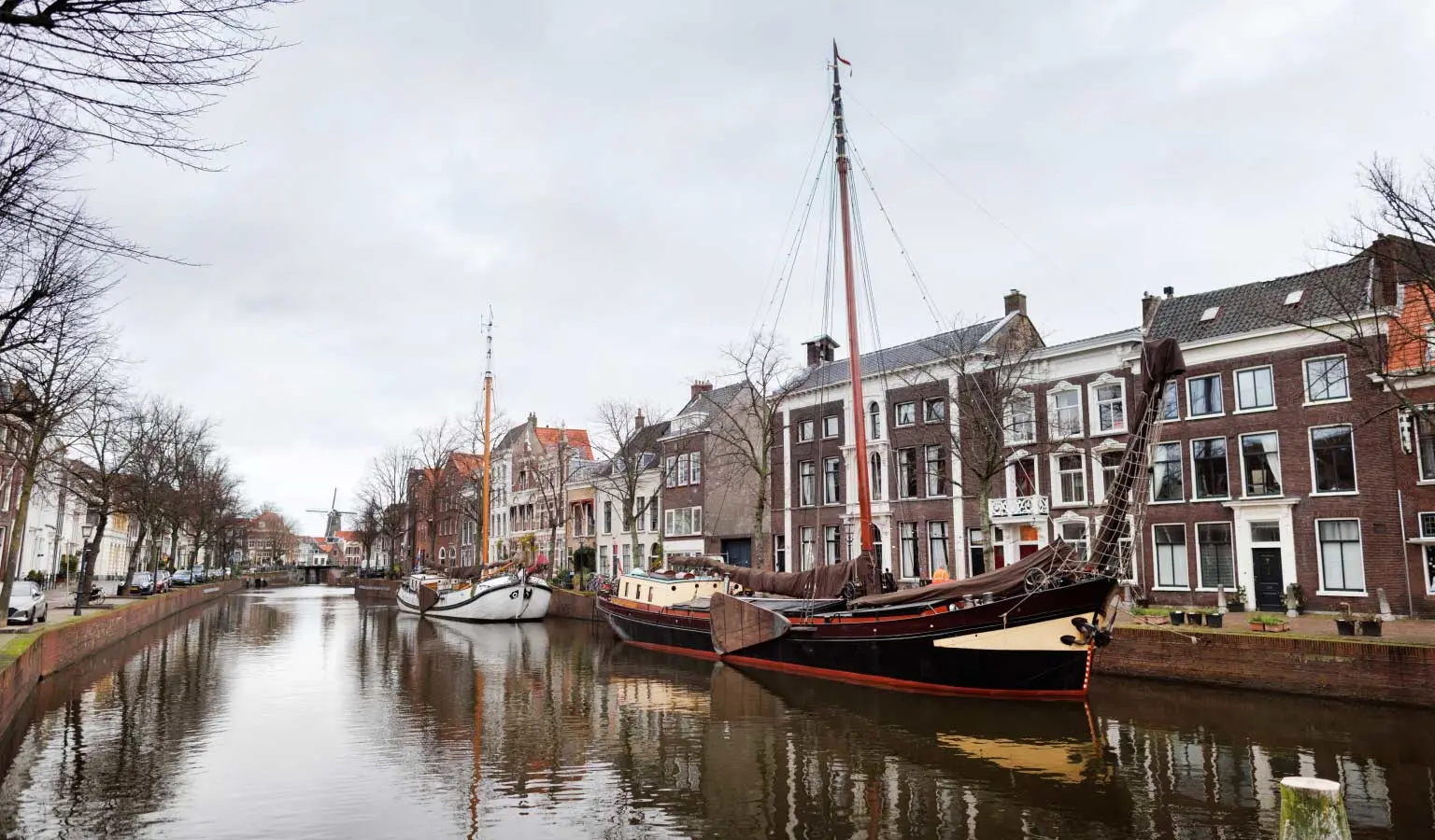 Gracht in Schiedam met op de voorgrond een oude zeilboot en op de achtergrond oud-Hollandse huizen.