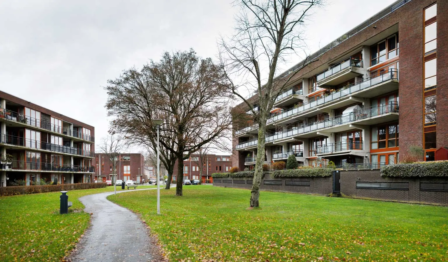 Grasveld met aan weerszijden moderne appartementencomplexen in de Rotterdamse wijk Oud-Charlois