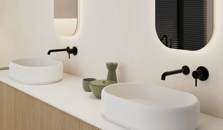 Twee ovale wasbakken met spiegels en zwarte kraan erboven.