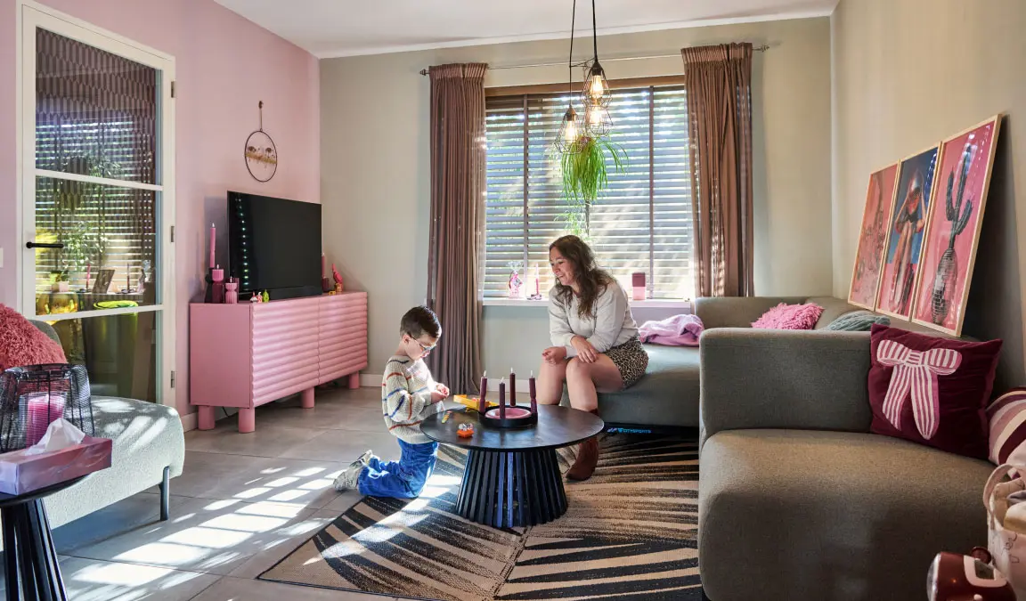 Lieke met haar zoontje Daan in de royale en lichte huiskamer met roze accenten van haar tussenwoning in Helmond. 