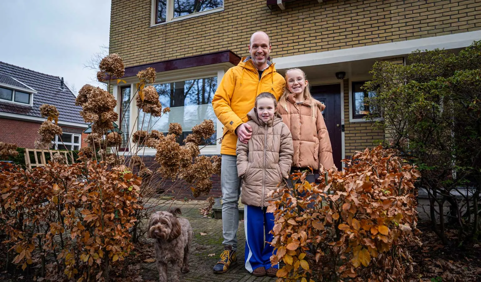 Inwoner van Zuidlaren Bastiaan Hollander met zijn twee dochters voor de deur van hun jarendertighuis.