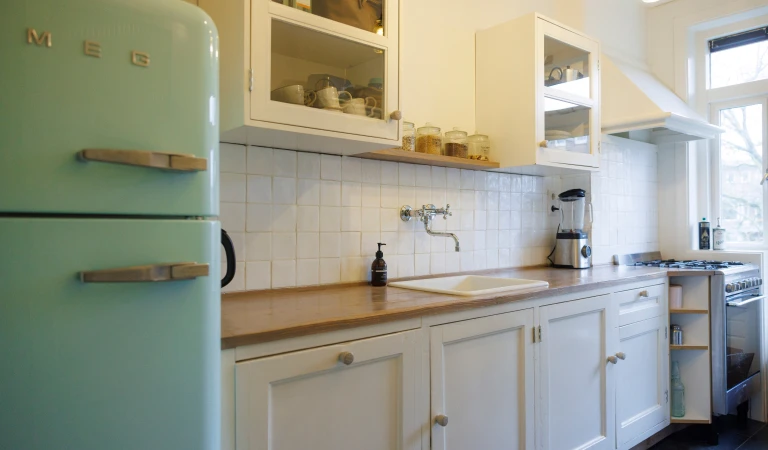 De keuken kreeg een make-over met nieuwe keukenkastjes, maar de oude paneeldeurtjes bleven.