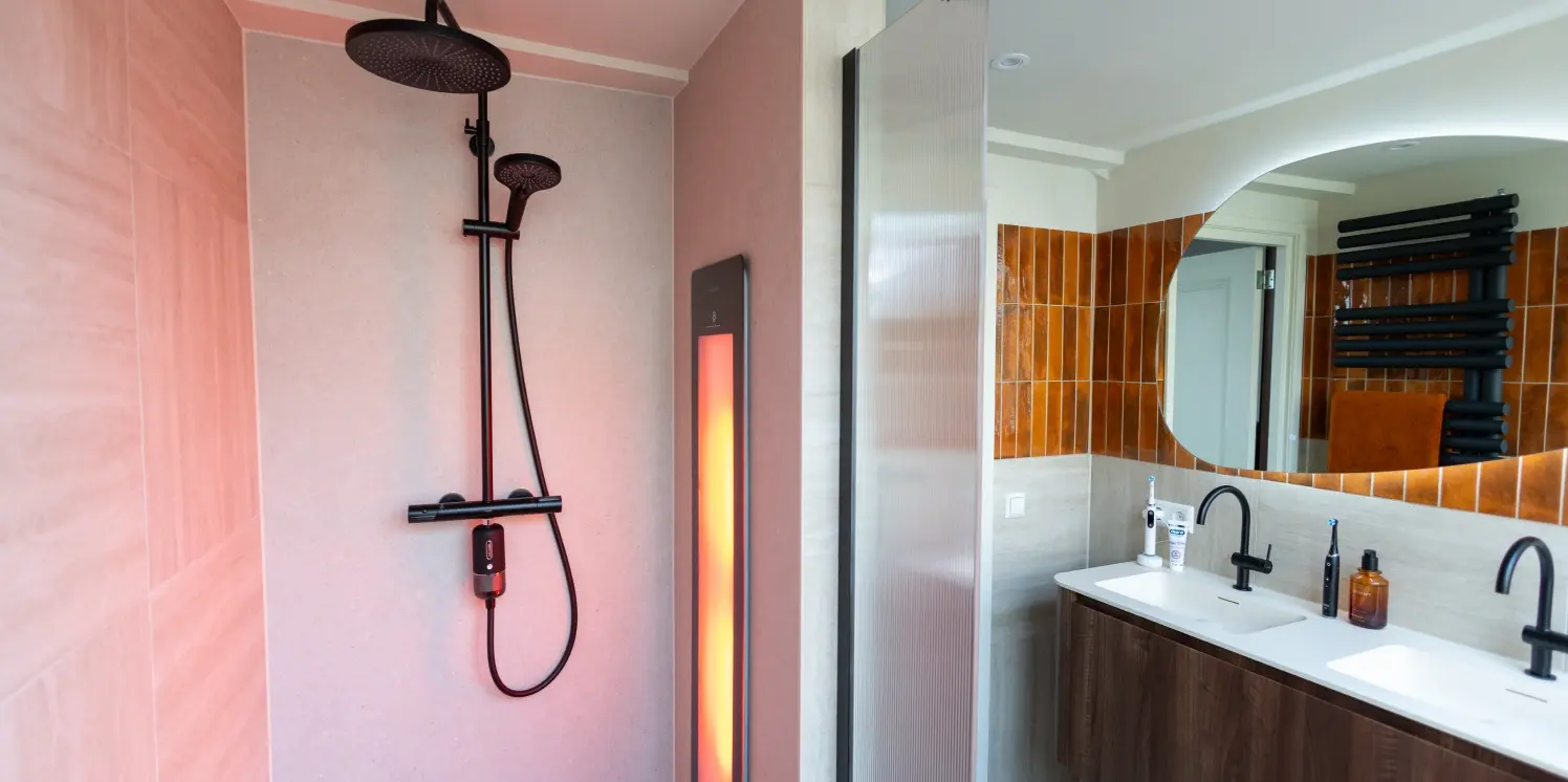 Gedeeltelijk aanzicht van badkamer, met links een sun shower en rechts de dubbele wastafel.