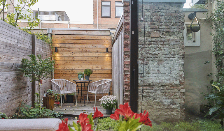 De kleine achtertuin van Djoeke en Goffe-Jan. Achterin is ruimte voor een klein zitje met twee stoelen. 