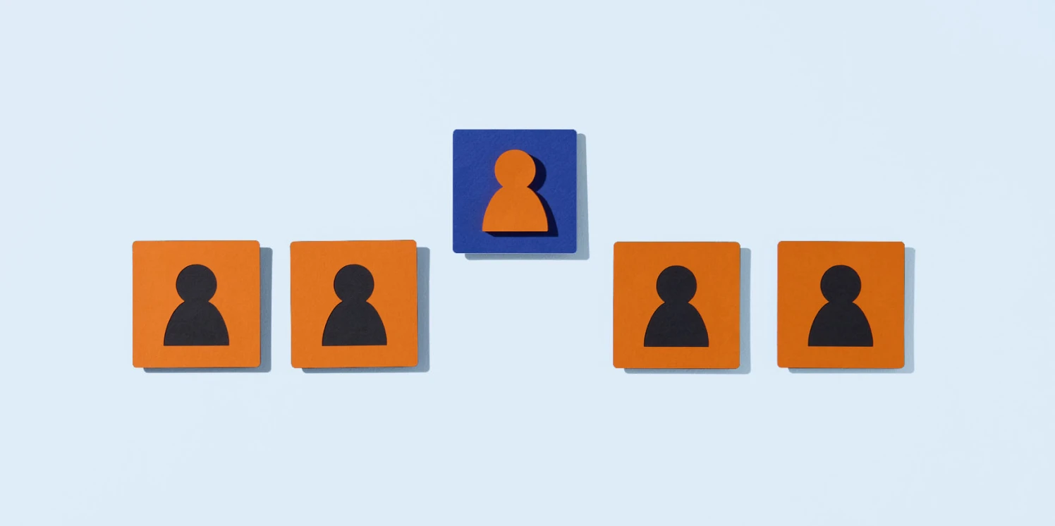 Vijf blokjes met figuratieve personen waarvan het middelste blokje een afwijkende kleur heeft en erbovenuit steekt.