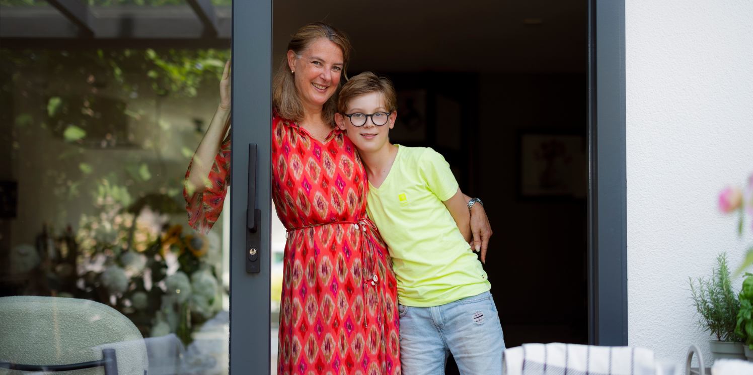 Wendel en haar zoon in de schuifpui in haar huis in Alphen aan den Rijn.