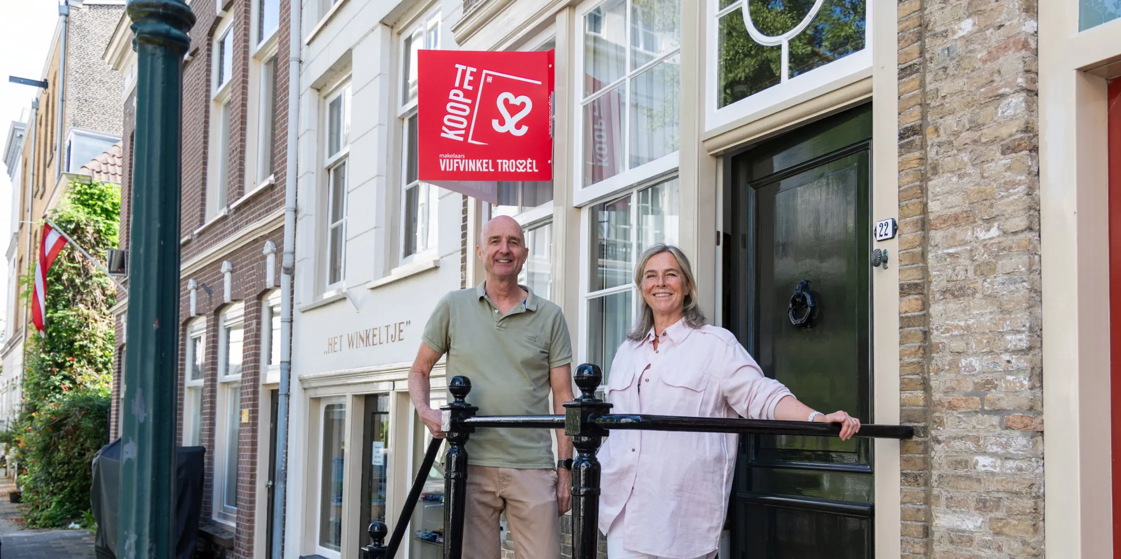 JanKees en Bastienne op de trap voor de ingang van hun ouderlijk huis en winkeltje.