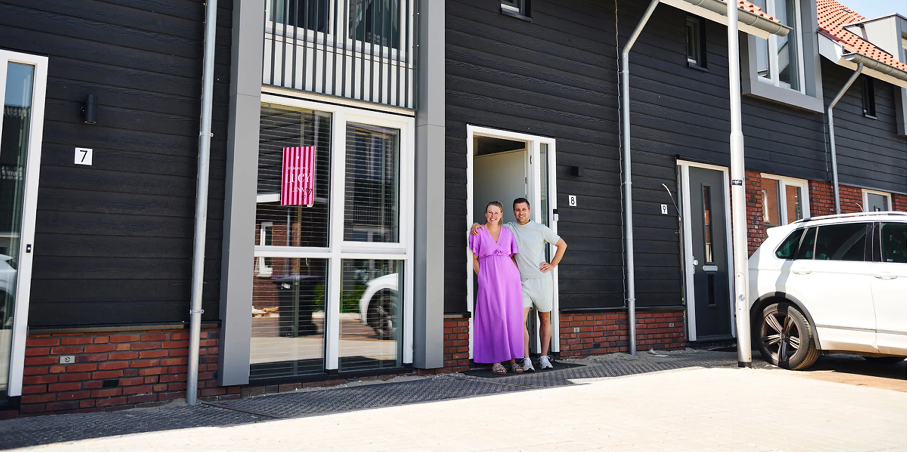 Karlijn en Jordy voor hun nieuwbouw tussenwoning in Hendrik-Ido-Ambacht met zwarte gevel.