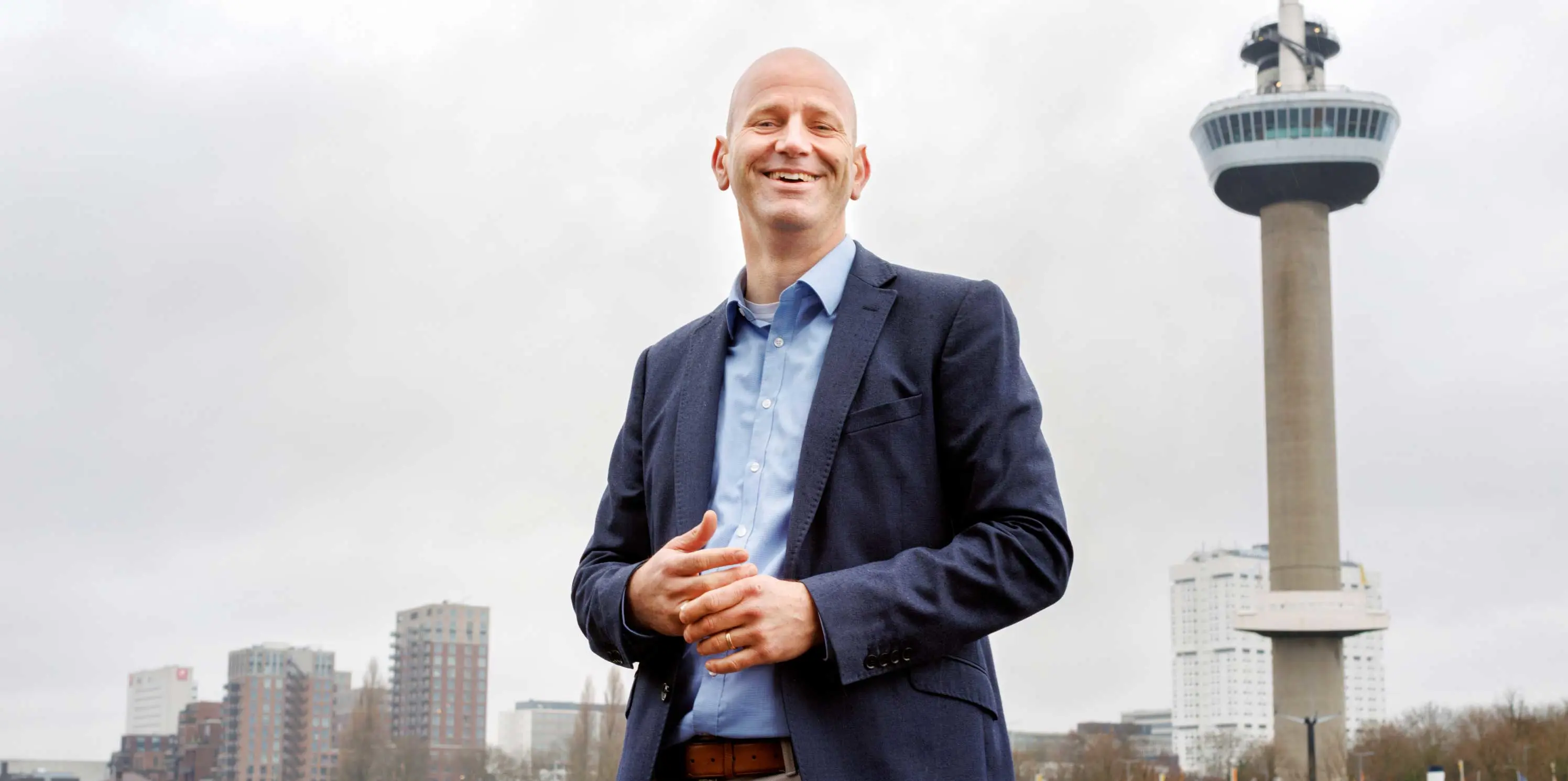 Makelaar Dimitri van Kleef van Van Kleed NVM Makelaars in Rotterdam, met op de achtergrond de Euromast.