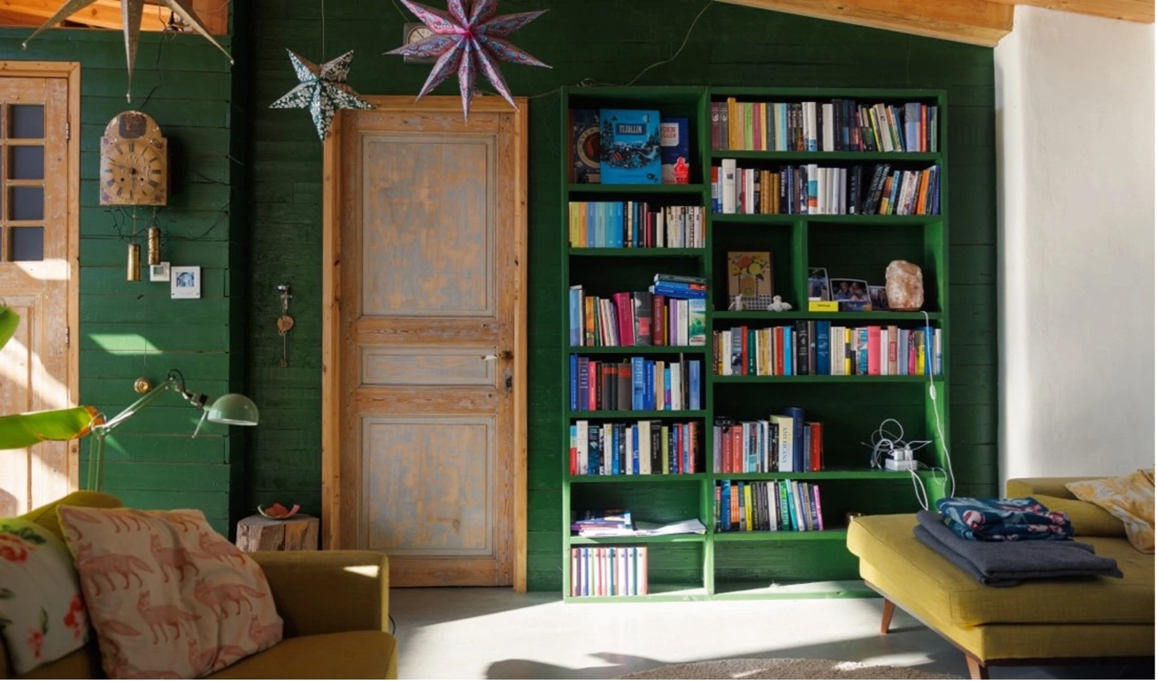 Groene wand met boekenkast in het aardehuis.